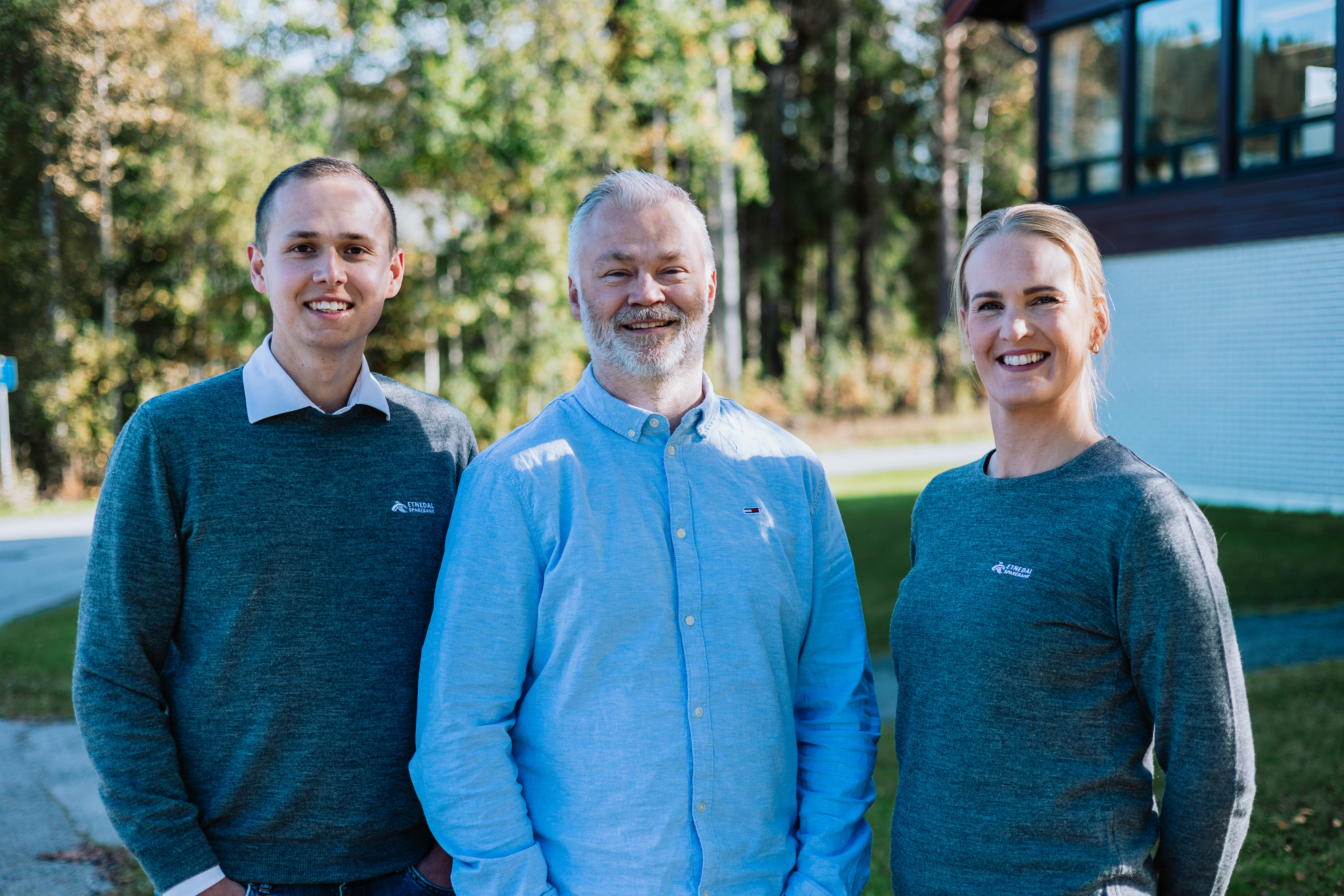 Tre personer som smiler mot kameraet