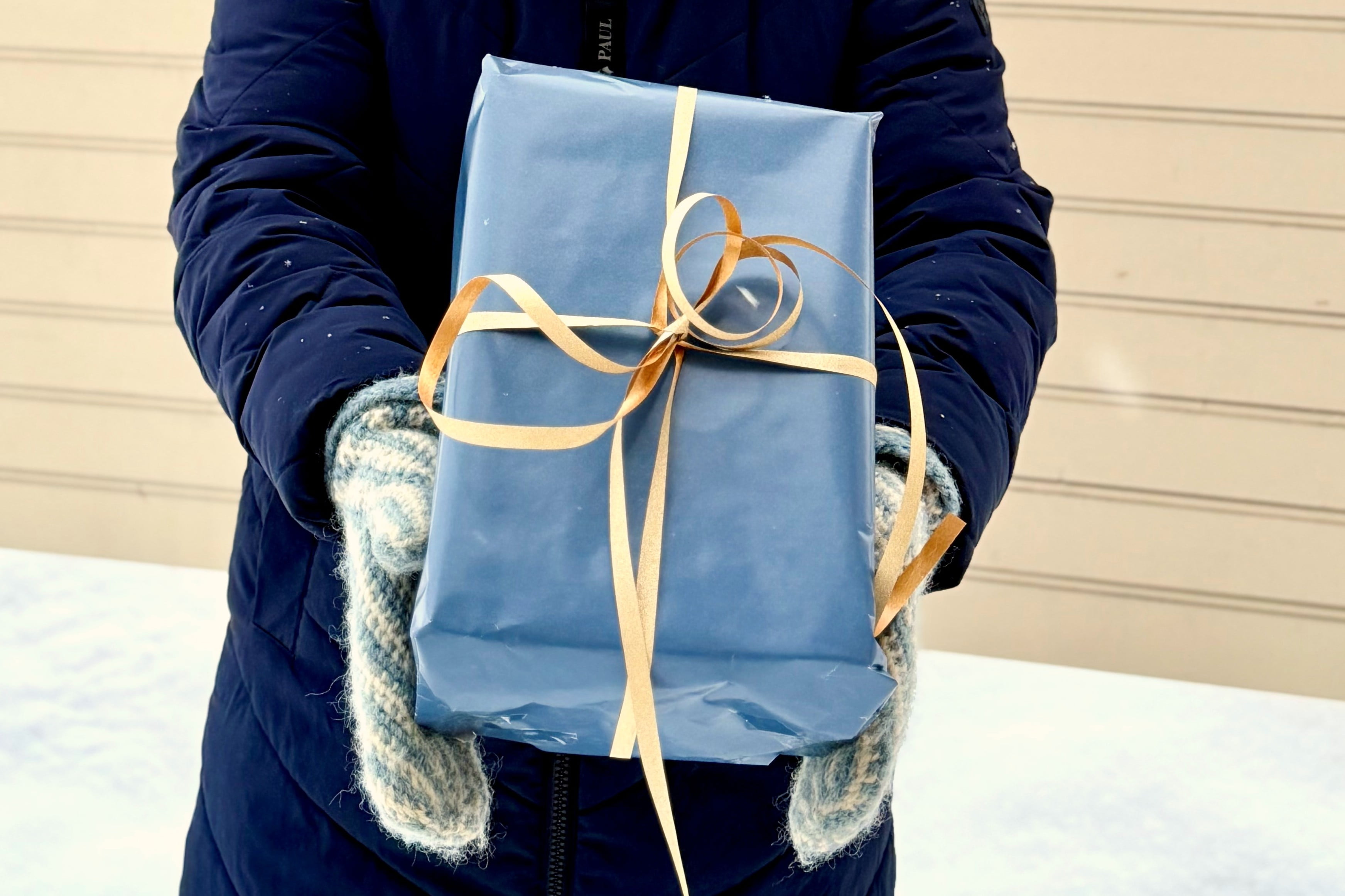 Hender som holder en innpakket gave