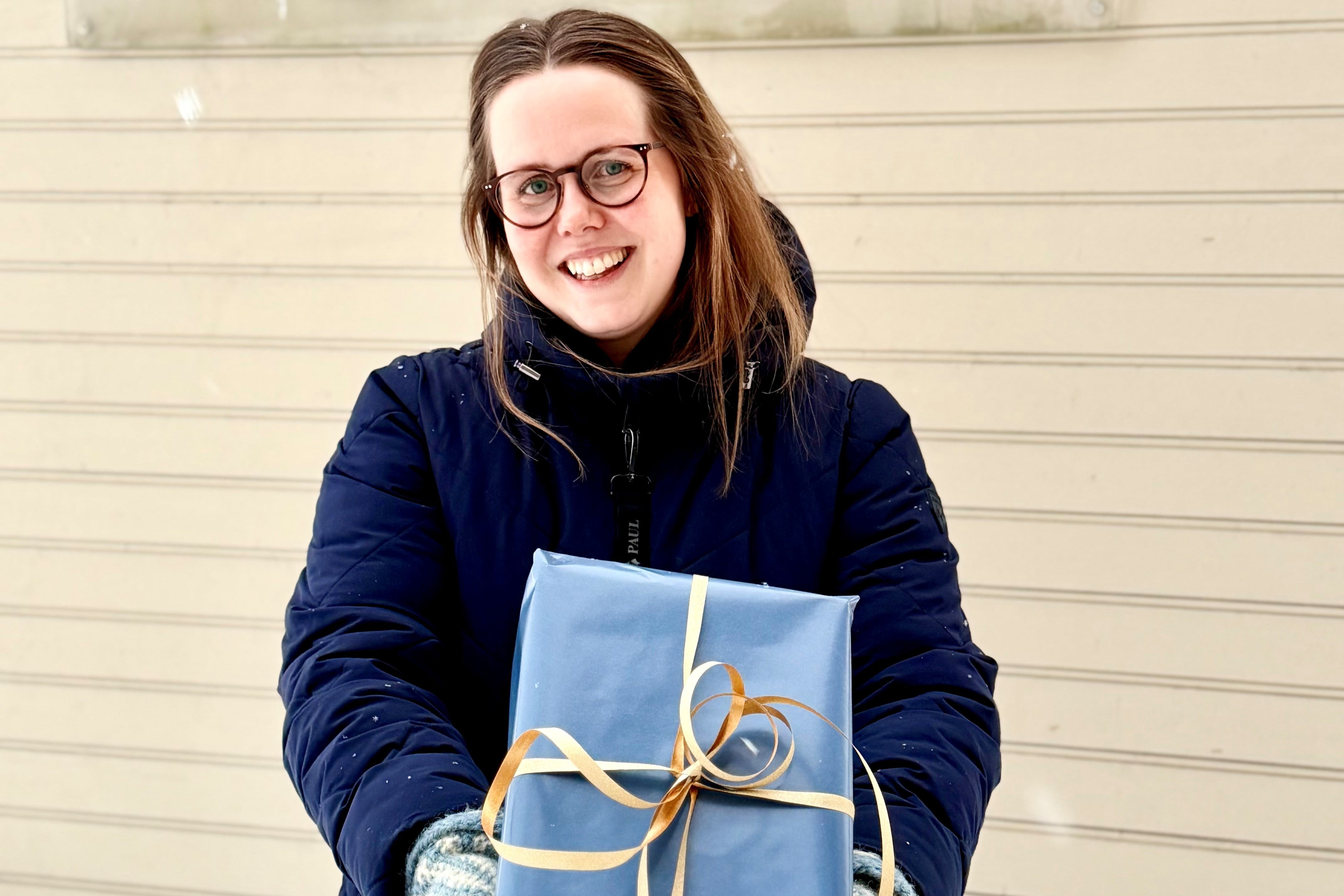 Jente som holder en innpakket gave